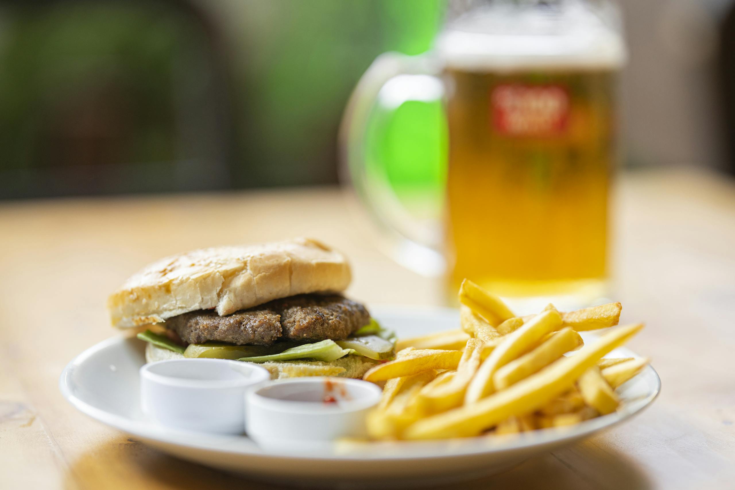 Delicious cheeseburger with fries and a beer, perfect for a classic meal.